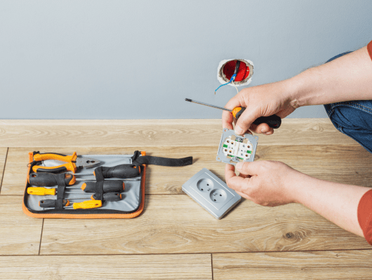 man installs electrical outlet gray wall 1 min